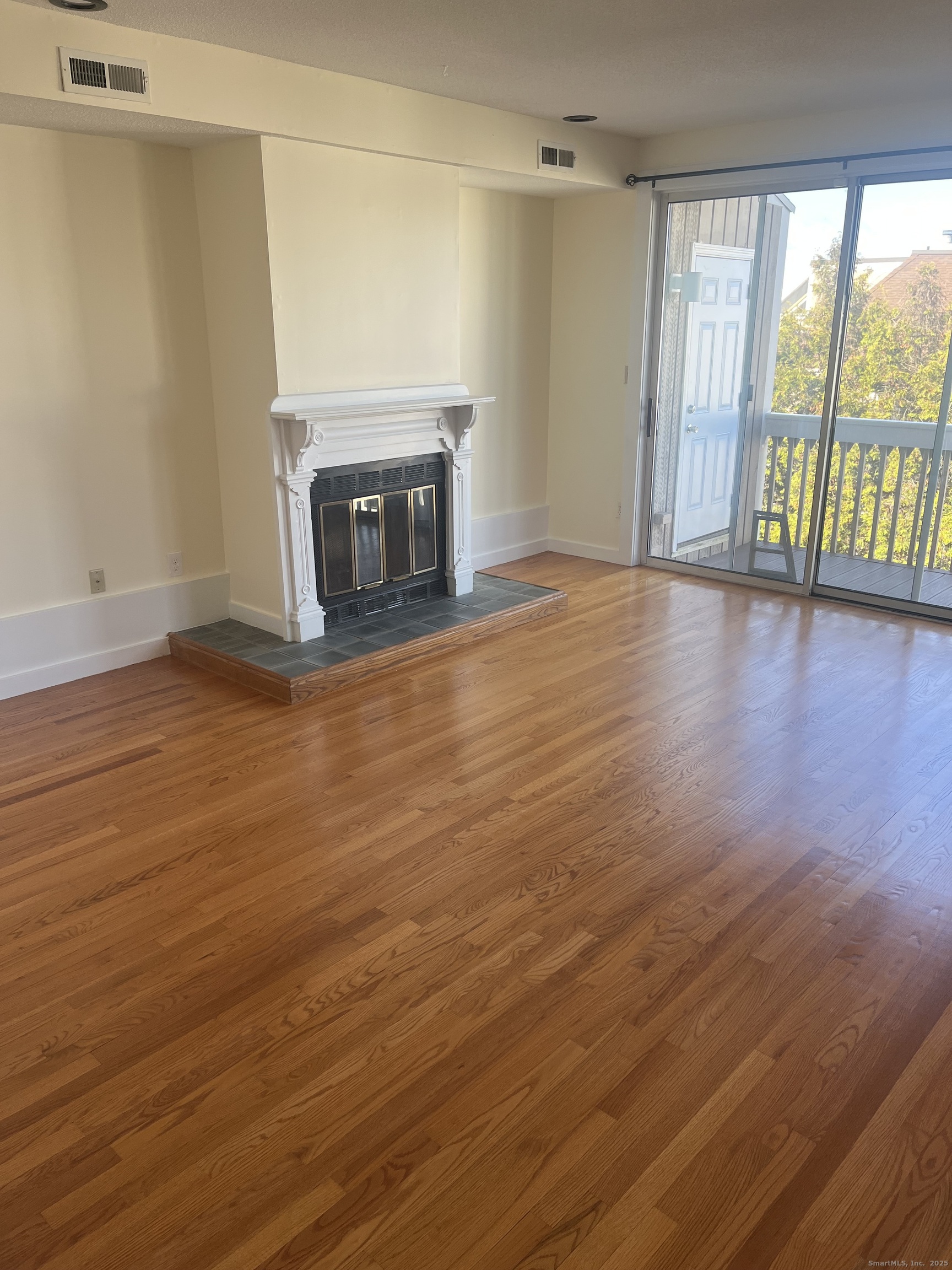 896 Quinnipiac Avenue, Unit 3 New Haven, CT 06513 - Photo 2 of 38 a view of empty room with wooden floor and fireplace