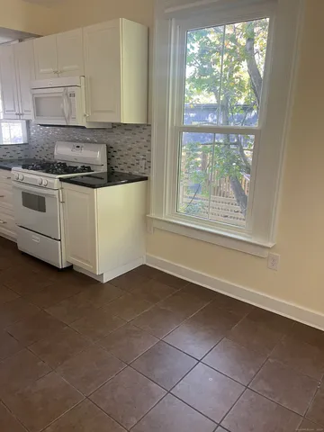a kitchen with a white cabinets and a stove top oven