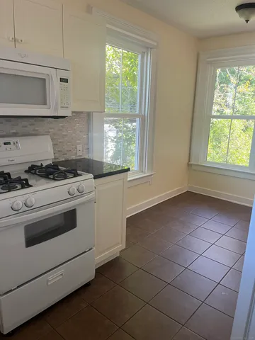 a kitchen with cabinets appliances and a window