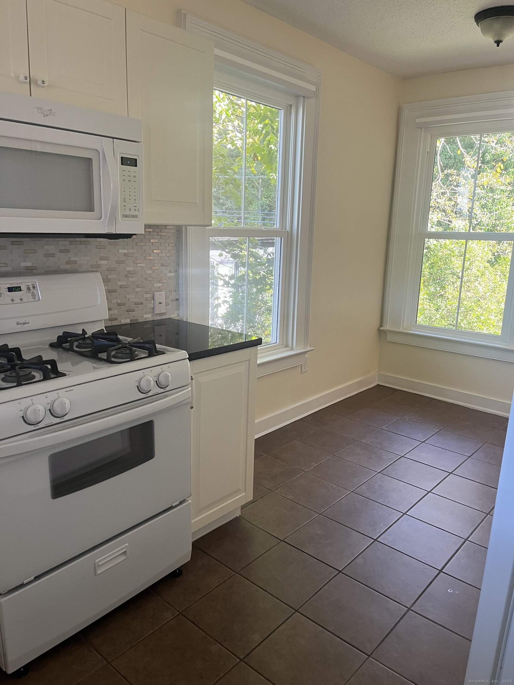 896 Quinnipiac Avenue, Unit 3 New Haven, CT 06513 - Photo 7 of 38 a kitchen with cabinets appliances and a window