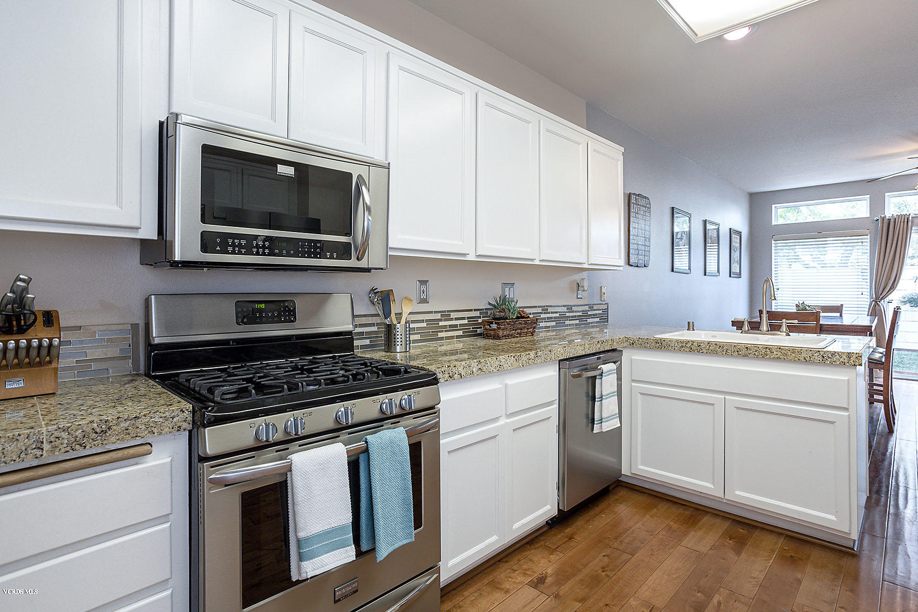 4251 Rusticview Court Moorpark, CA 93021 - Photo 5 of 27 a kitchen with white cabinets stainless steel appliances and sink