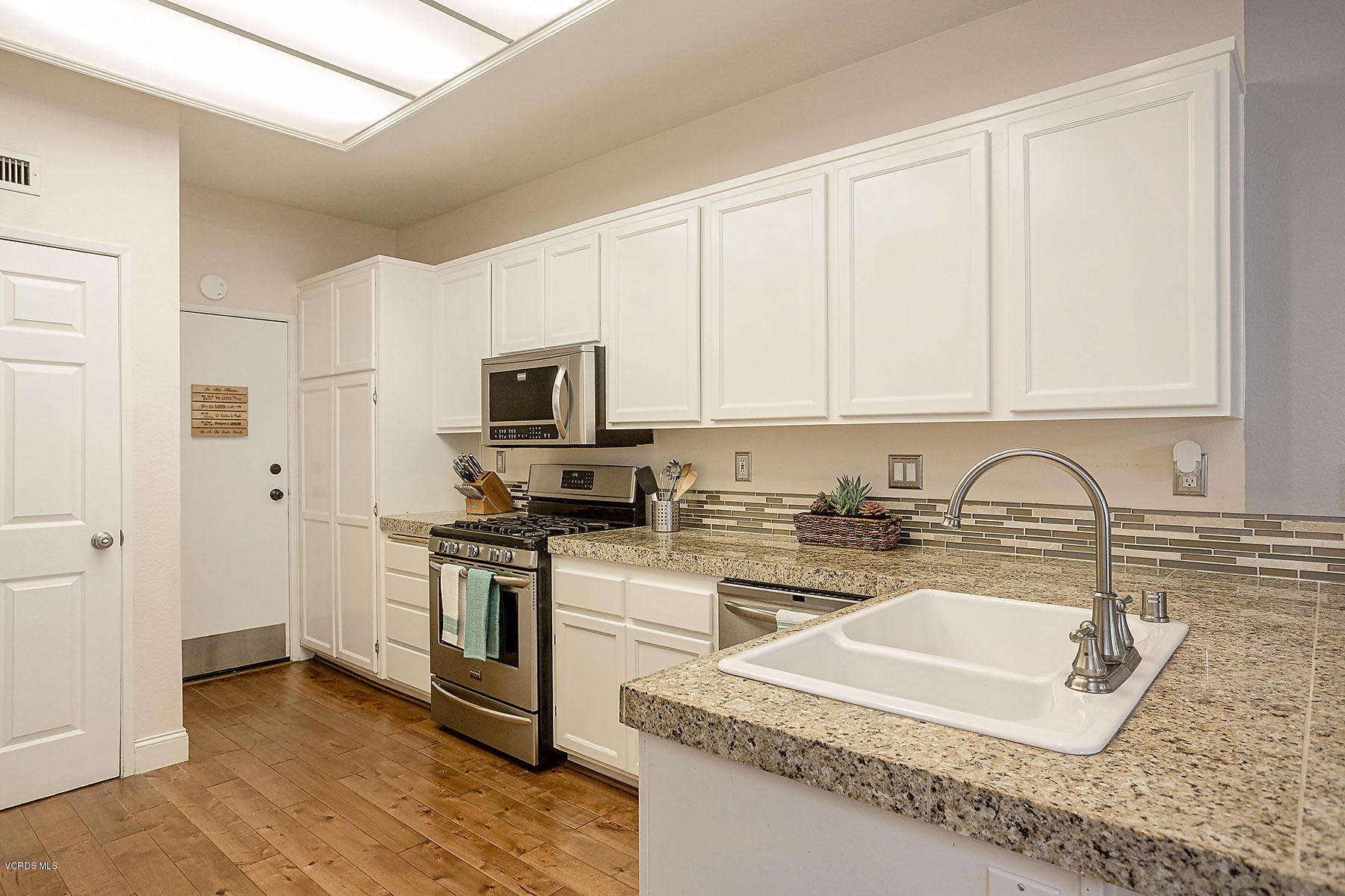 4251 Rusticview Court Moorpark, CA 93021 - Photo 6 of 27 a kitchen with stainless steel appliances granite countertop a sink a stove a microwave and a refrigerator