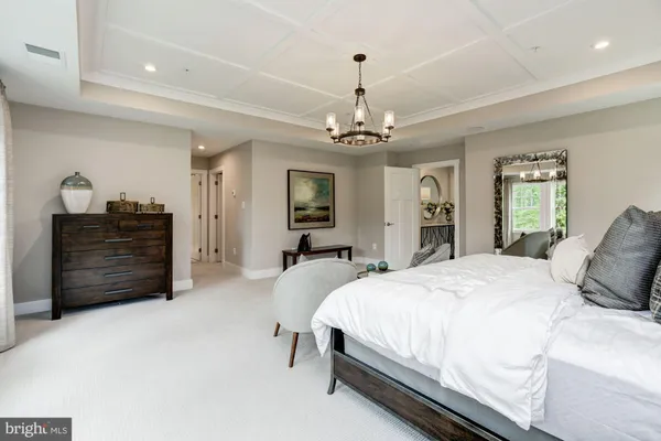 a spacious bedroom with a bed and dresser