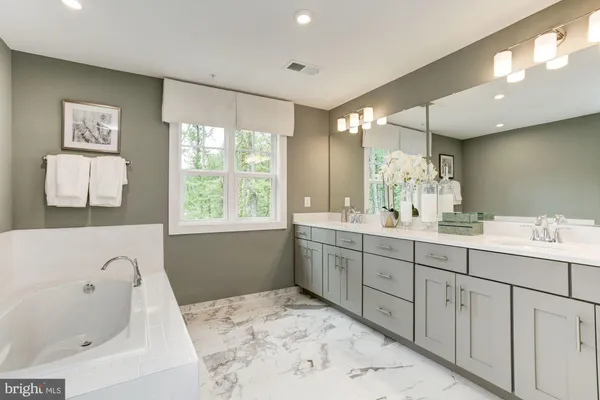 a bathroom with a tub sink and mirror