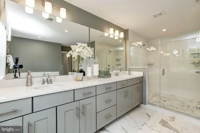 a bathroom with a sink shower and a mirror