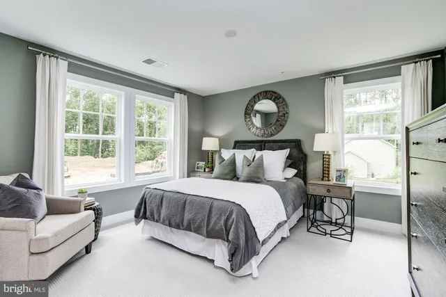 a bedroom with a bed a couch and a large window