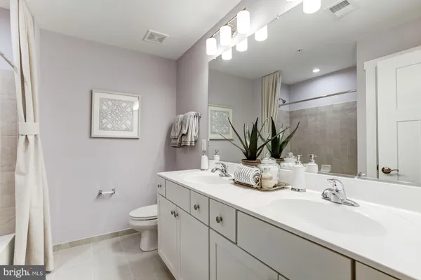 a bathroom with a double vanity sink mirror and toilet