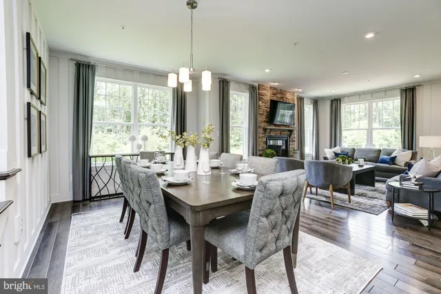 a view of a dining room and livingroom with furniture wooden floor a chandelier