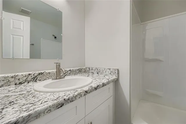 a bathroom with a granite countertop sink and a mirror