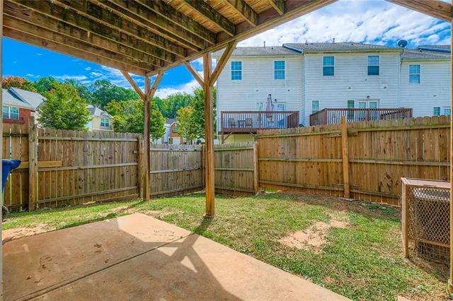 a view of backyard with wooden fence