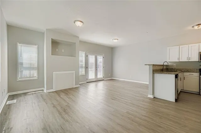 a view of a kitchen with wooden floor and a window