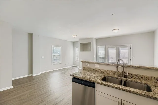 a kitchen with granite countertop a sink and wooden floor