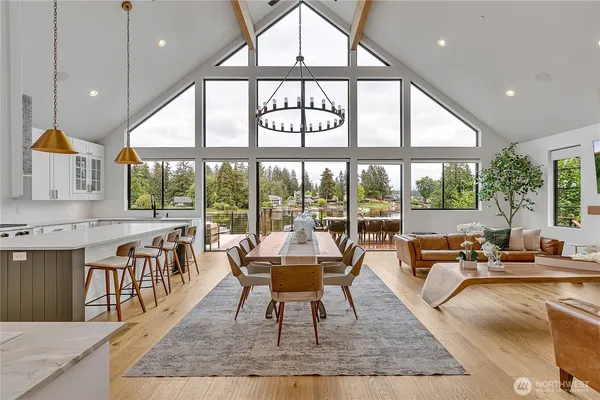 a large room with kitchen view and large windows