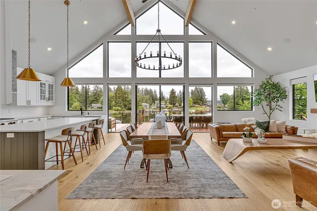 a large room with kitchen view and large windows