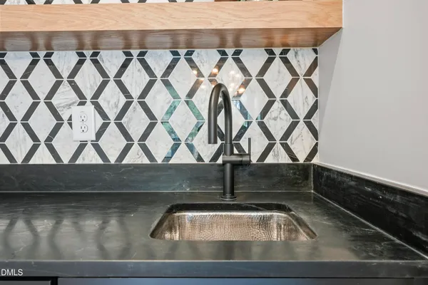 a dining room with wooden floor a chandelier a glass table and chairs