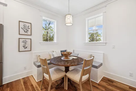a view of a dining room with furniture a chandelier and wooden floor