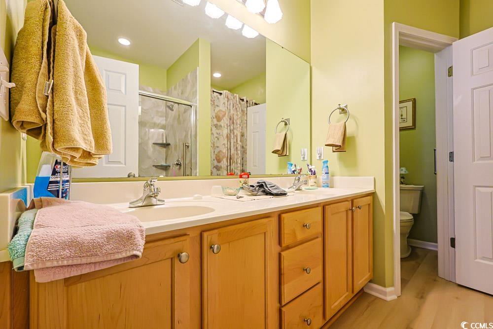 75 Field Planters Circle, Unit 75 Calabash, NC 28467 - Photo 17 of 40 Bathroom with a stall shower, double vanity, and light wood-style flooring