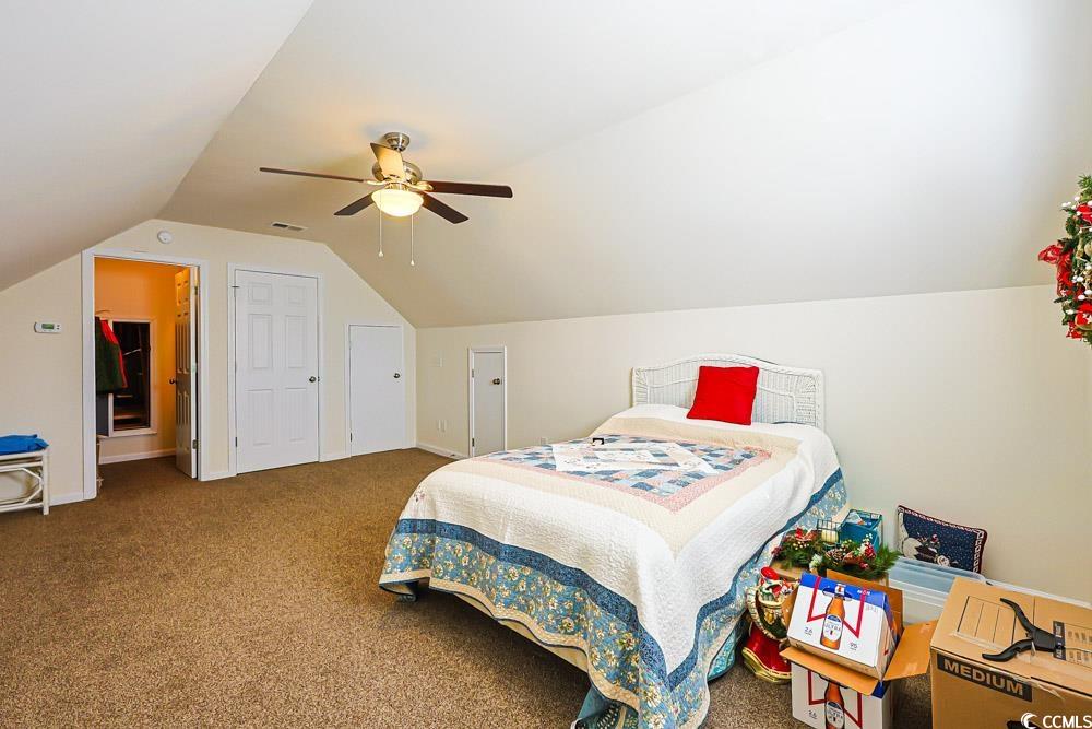 75 Field Planters Circle, Unit 75 Calabash, NC 28467 - Photo 19 of 40 Bedroom with vaulted ceiling, carpet, and a ceiling fan