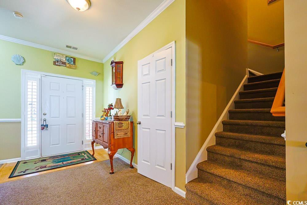 75 Field Planters Circle, Unit 75 Calabash, NC 28467 - Photo 22 of 40 Carpeted foyer featuring ornamental molding and stairway