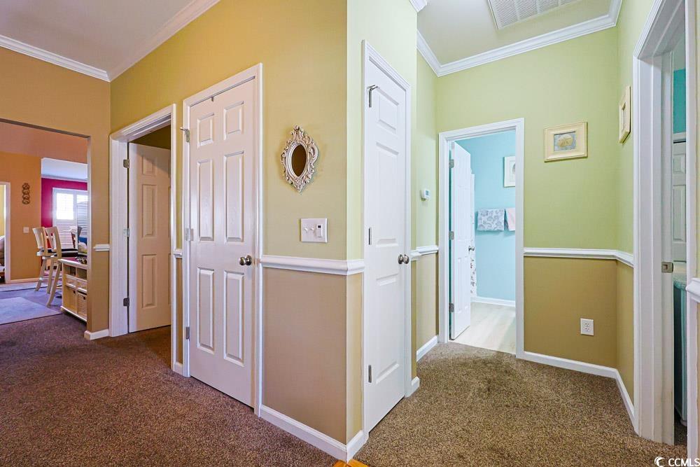 75 Field Planters Circle, Unit 75 Calabash, NC 28467 - Photo 27 of 40 Hallway featuring crown molding and dark colored carpet