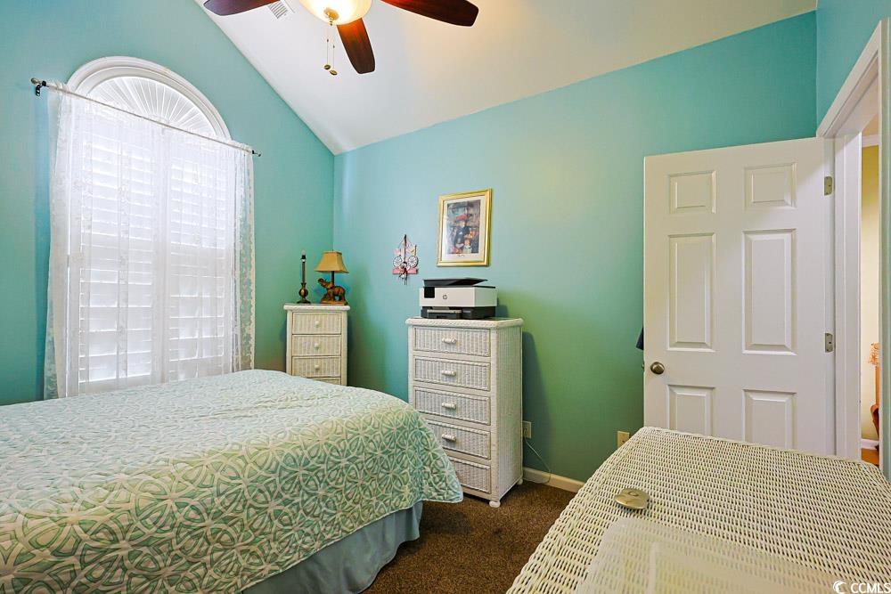 75 Field Planters Circle, Unit 75 Calabash, NC 28467 - Photo 30 of 40 Bedroom with dark carpet, vaulted ceiling, and ceiling fan