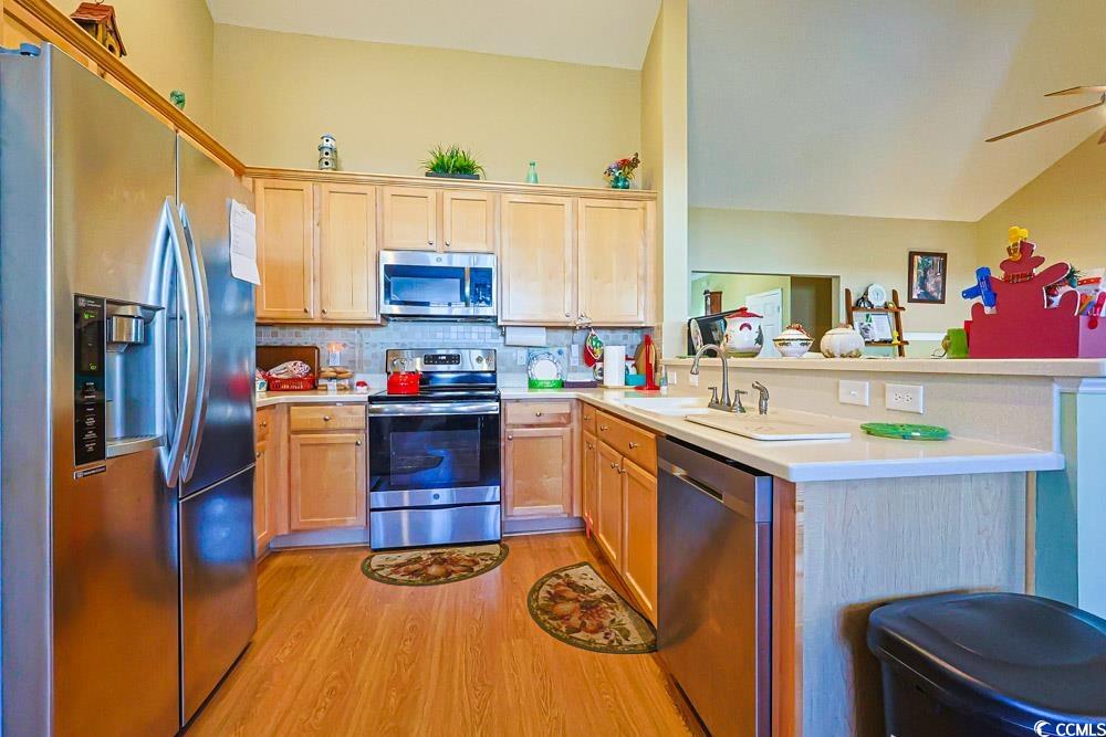 75 Field Planters Circle, Unit 75 Calabash, NC 28467 - Photo 6 of 40 Kitchen with stainless steel appliances, backsplash, light wood finished floors, a peninsula, and lofted ceiling