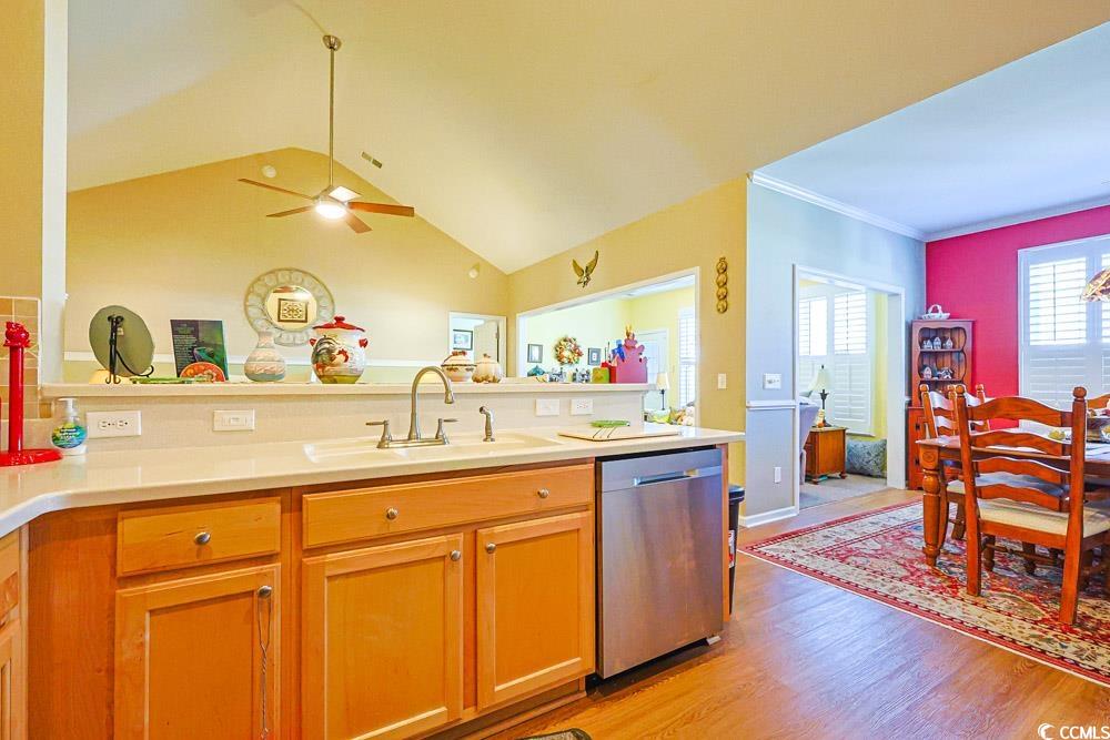 75 Field Planters Circle, Unit 75 Calabash, NC 28467 - Photo 8 of 40 Kitchen featuring dishwasher, light wood-style floors, vaulted ceiling, ornamental molding, and brown cabinets