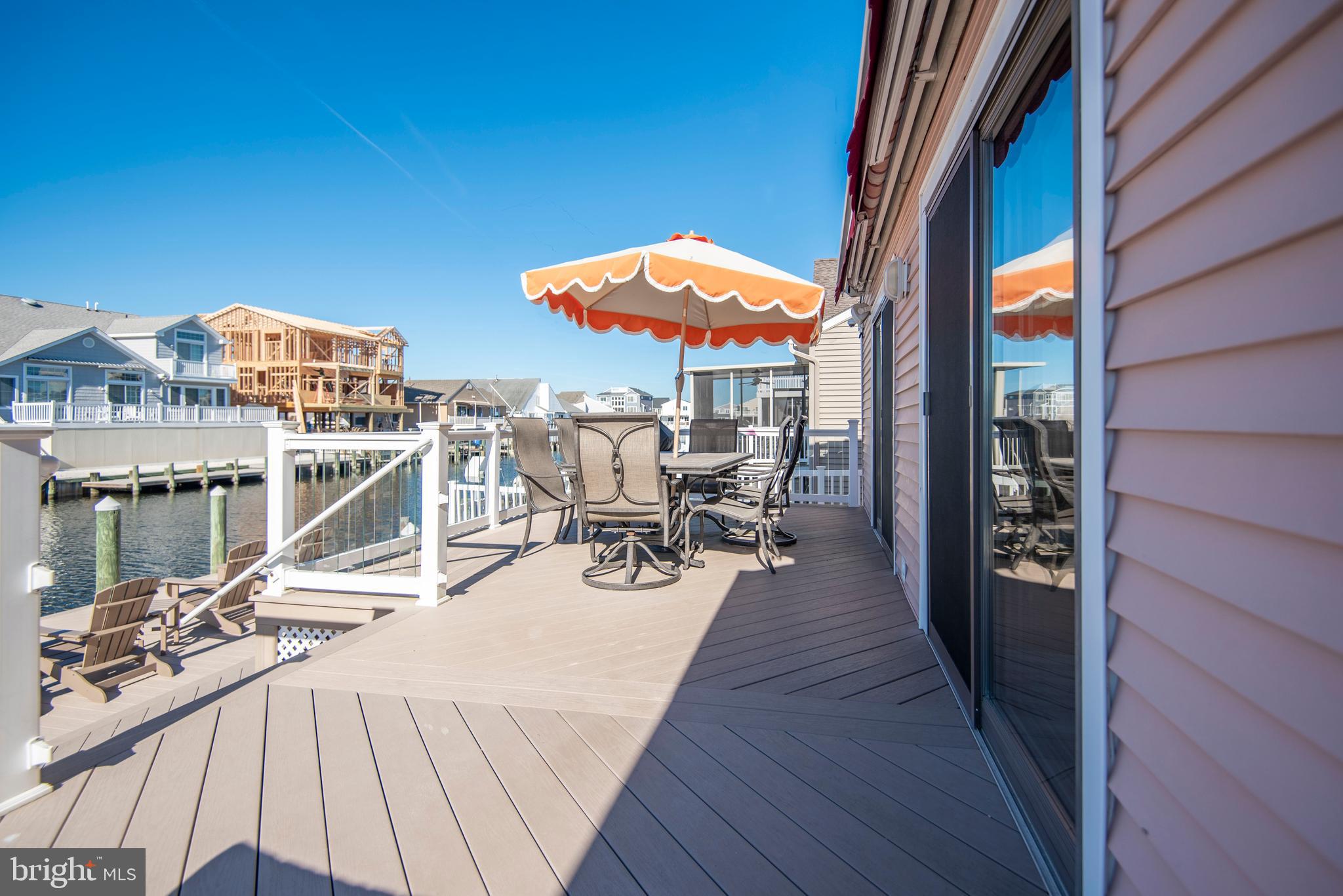 28 Diane Road Manahawkin, NJ 08050 - Photo 17 of 46 a view of a roof deck with table and chairs under an umbrella with wooden floor