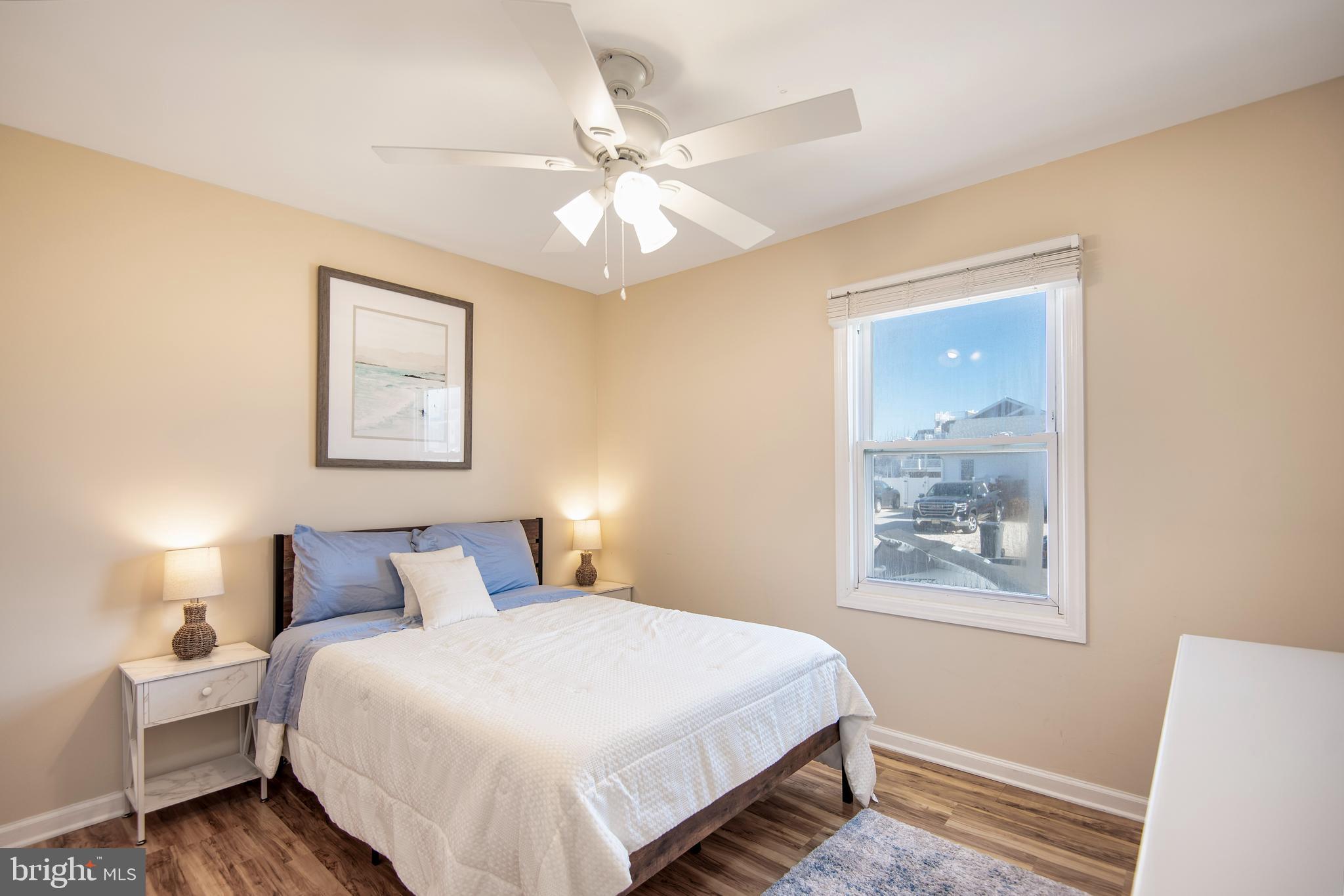 28 Diane Road Manahawkin, NJ 08050 - Photo 35 of 46 a bedroom with a large bed and a chandelier