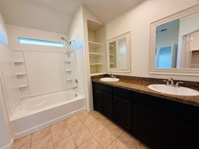 a bathroom with a granite countertop sink mirror and a bath tub