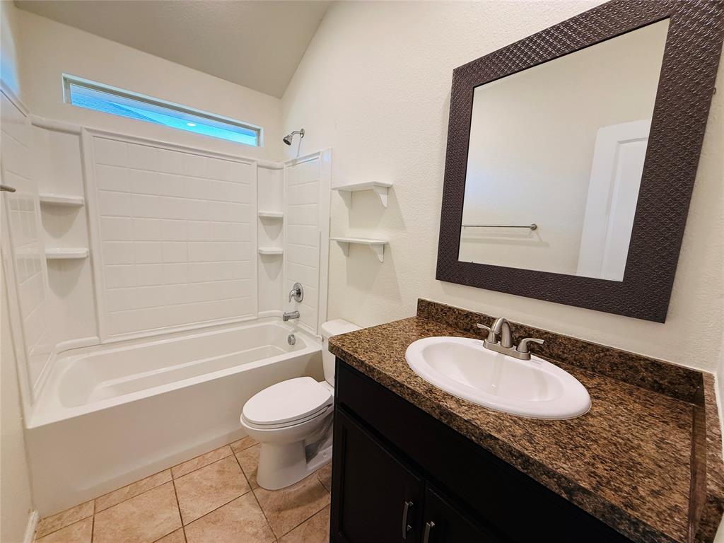 9328 Castorian Drive Fort Worth, TX 76131 - Photo 19 of 24 a bathroom with a granite countertop sink a toilet a mirror and shower