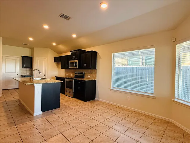 a kitchen with stainless steel appliances granite countertop a stove top oven a sink a counter top space and cabinets