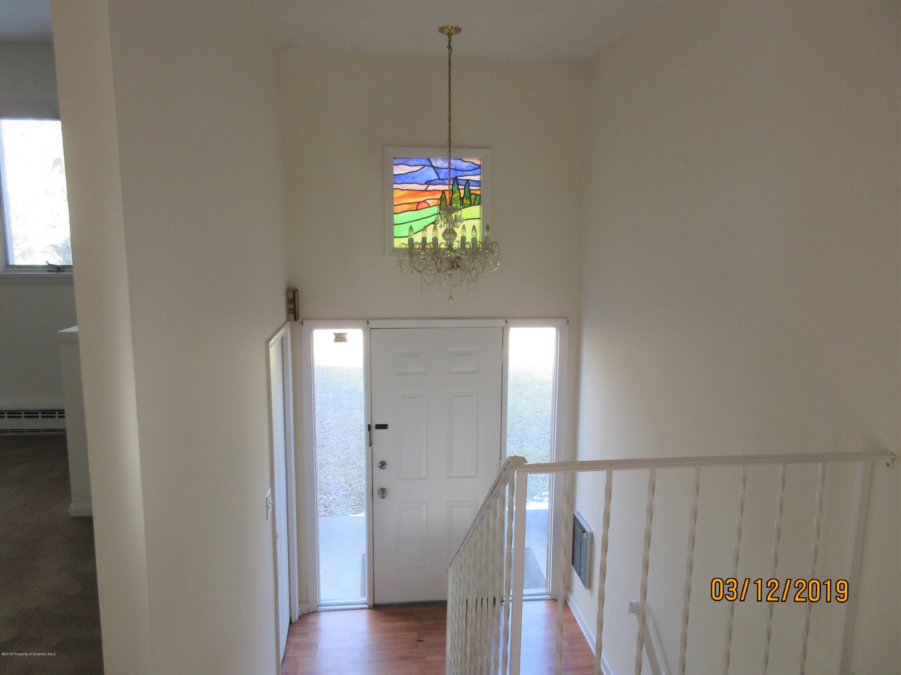 719 North Abington Road Clarks Summit, PA 18411 - Photo 20 of 37 a hallway with wooden floor chandelier and entryway