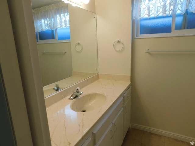 2148 Carolyn Way Bountiful, UT 84010 - Photo 22 of 40 Bathroom vanity featuring a built-in oval sink with a chrome faucet, set into a stone-finish countertop