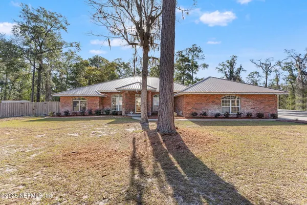a front view of a house with a yard and swimming pool
