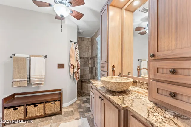 a bathroom with a granite countertop sink a vanity and a mirror