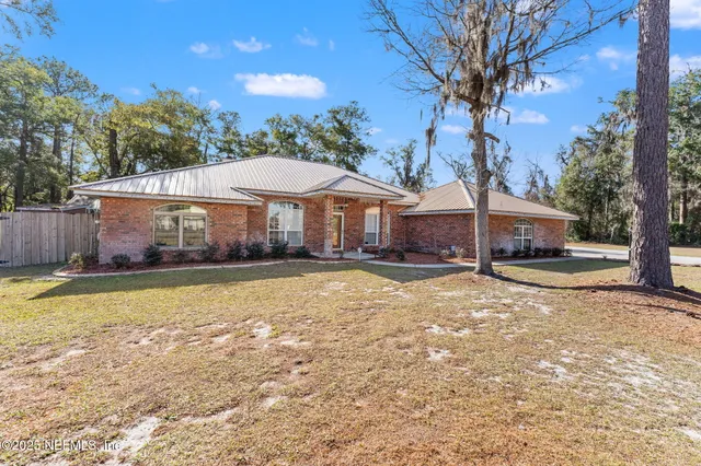 a front view of a house with a yard and swimming pool