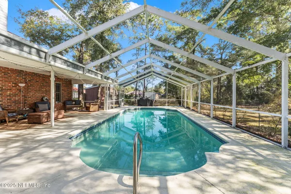 a view of a swimming pool with a patio and plants