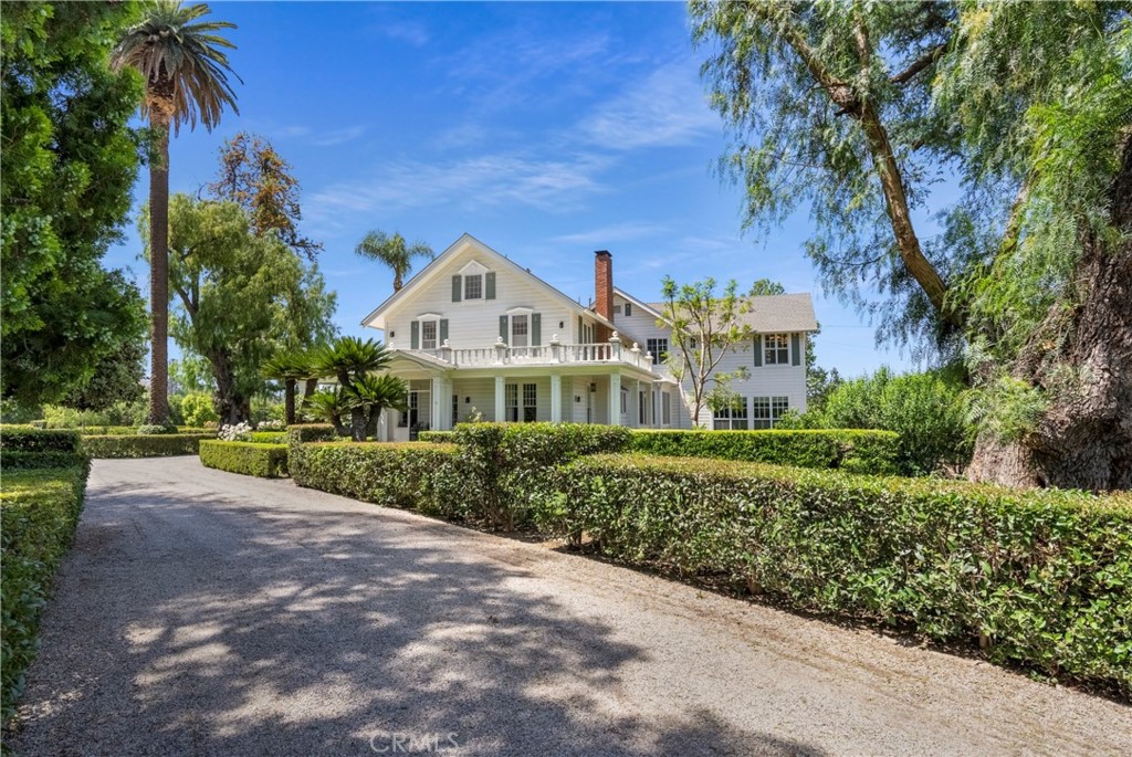 a front view of a house with a yard and shrubs