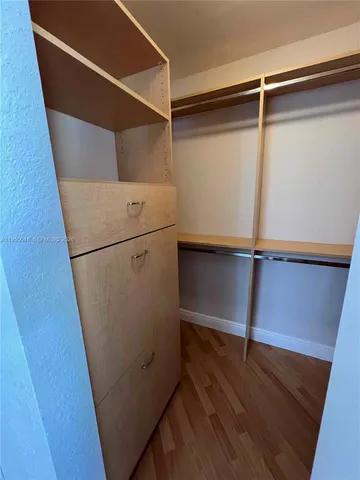 a utility room with wooden floor and white walls