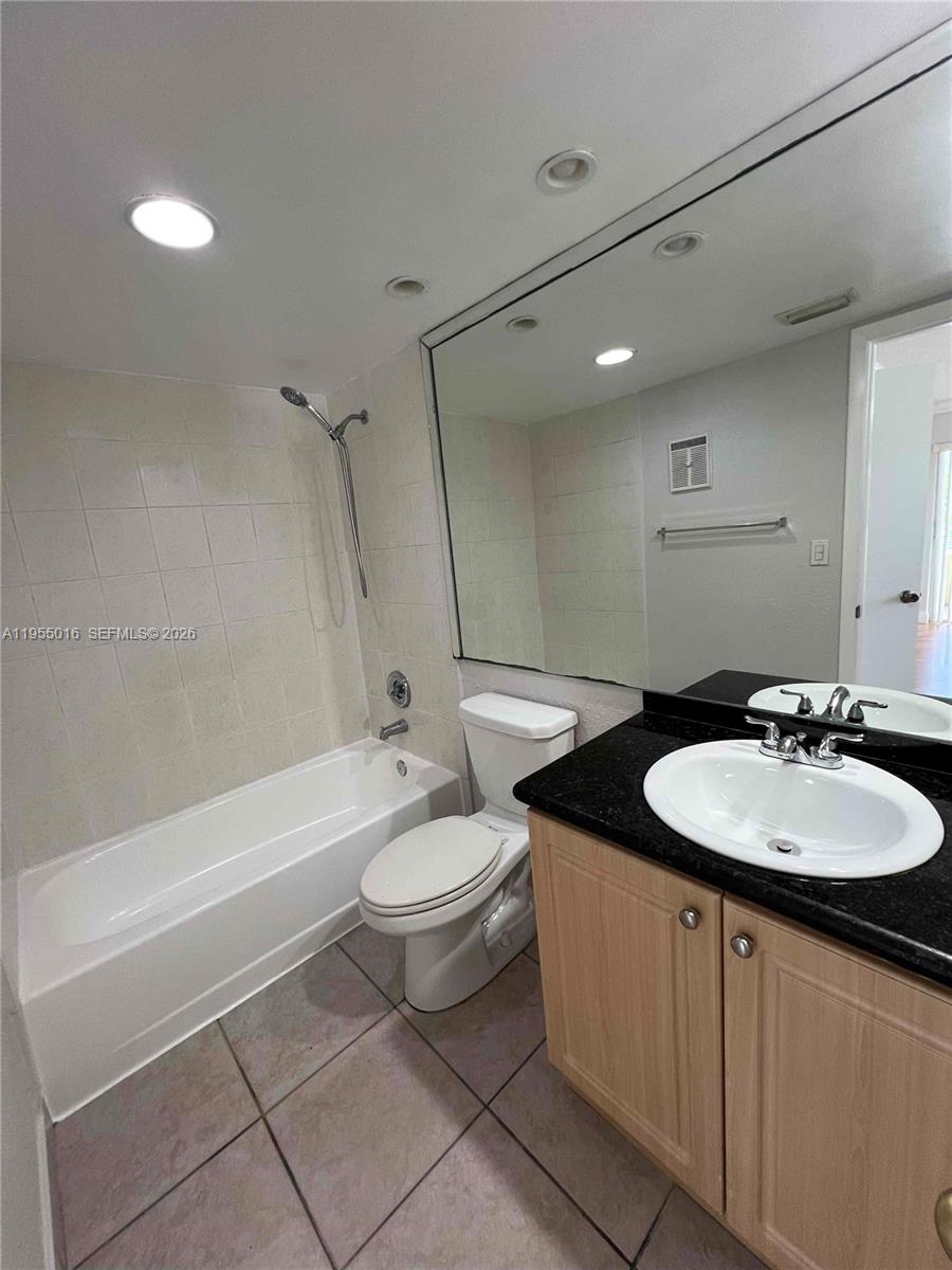 10785 Southwest 108th Avenue, Unit 308 Miami, FL 33176 - Photo 17 of 21 a bathroom with a double vanity sink toilet mirror and bathtub