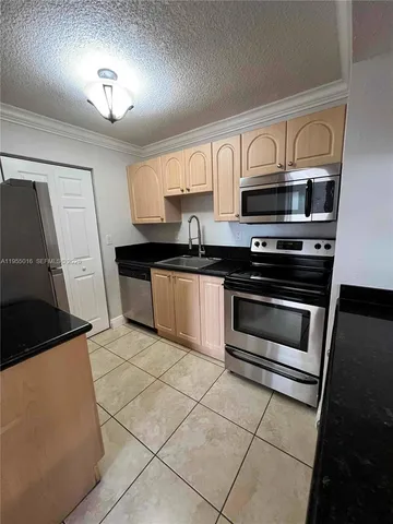 a kitchen with stainless steel appliances granite countertop a stove a microwave and a sink