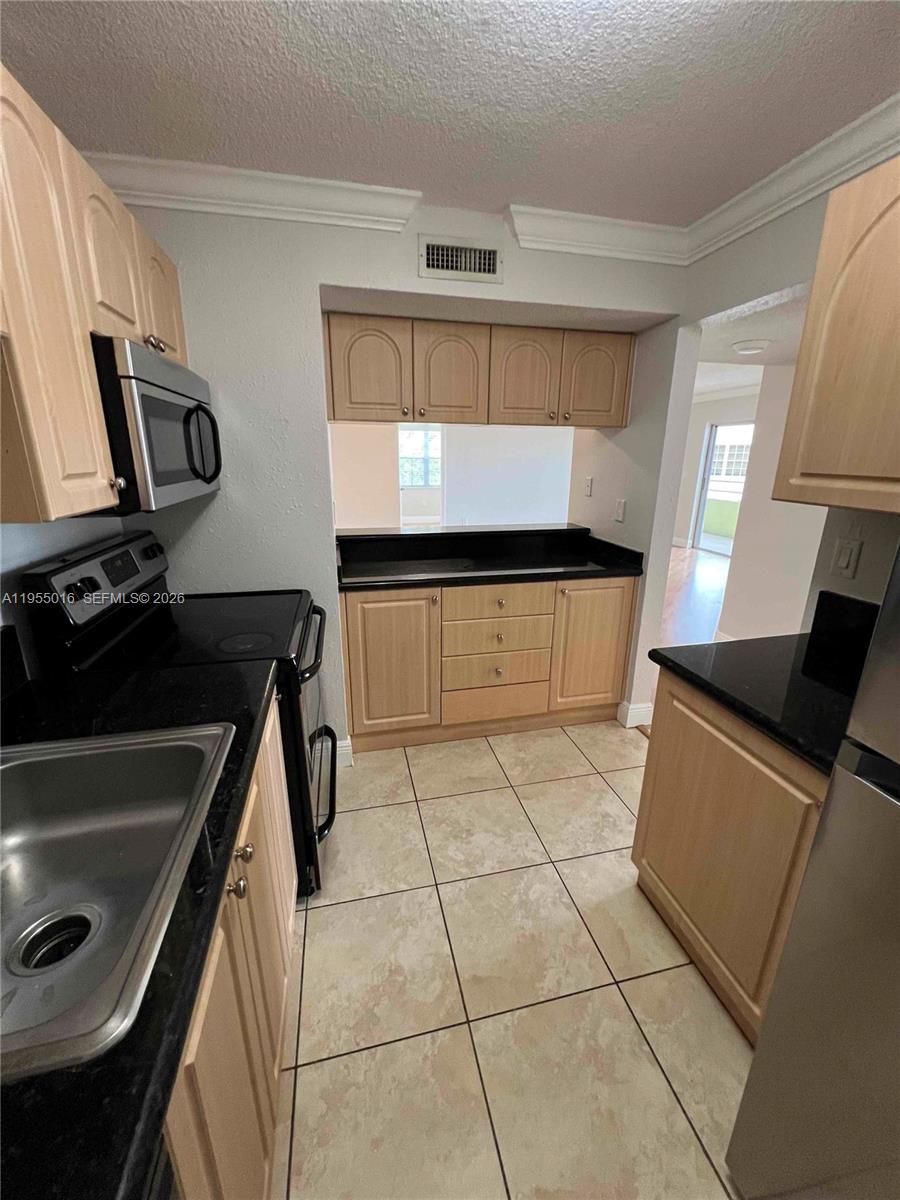 10785 Southwest 108th Avenue, Unit 308 Miami, FL 33176 - Photo 7 of 21 a kitchen with stainless steel appliances a sink stove and cabinets