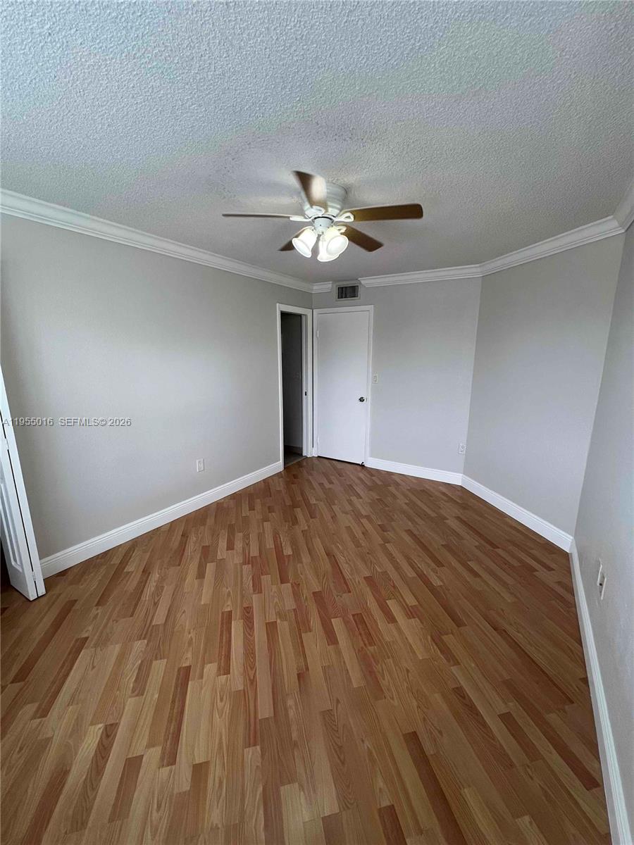 10785 Southwest 108th Avenue, Unit 308 Miami, FL 33176 - Photo 10 of 21 a view of empty room with wooden floor and fan