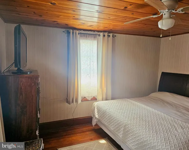 a bedroom with a bed dresser and a window
