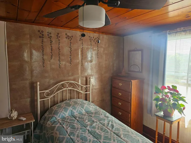 a bedroom with a bed dresser and a window