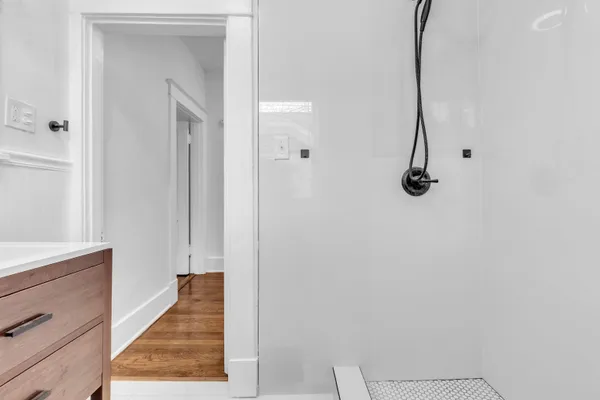 a view of a hallway with wooden floor and staircase