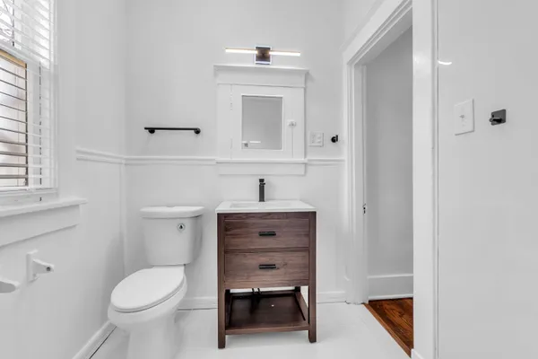 a bathroom with a toilet a sink a vanity and mirror