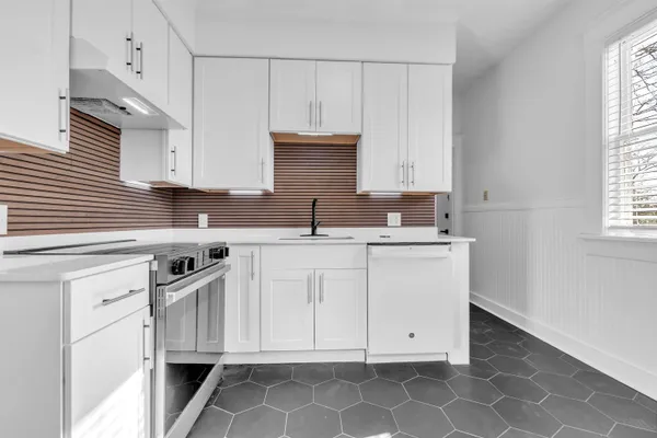 a kitchen with stainless steel appliances granite countertop a sink stove and cabinets