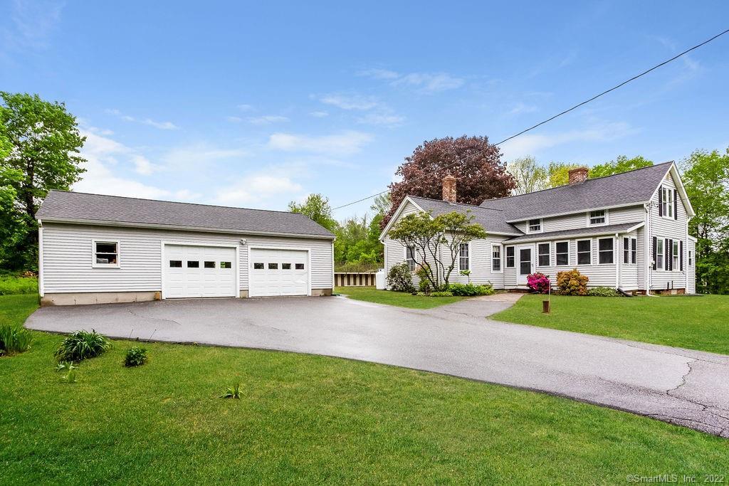 a view of a house with a yard and potted plants